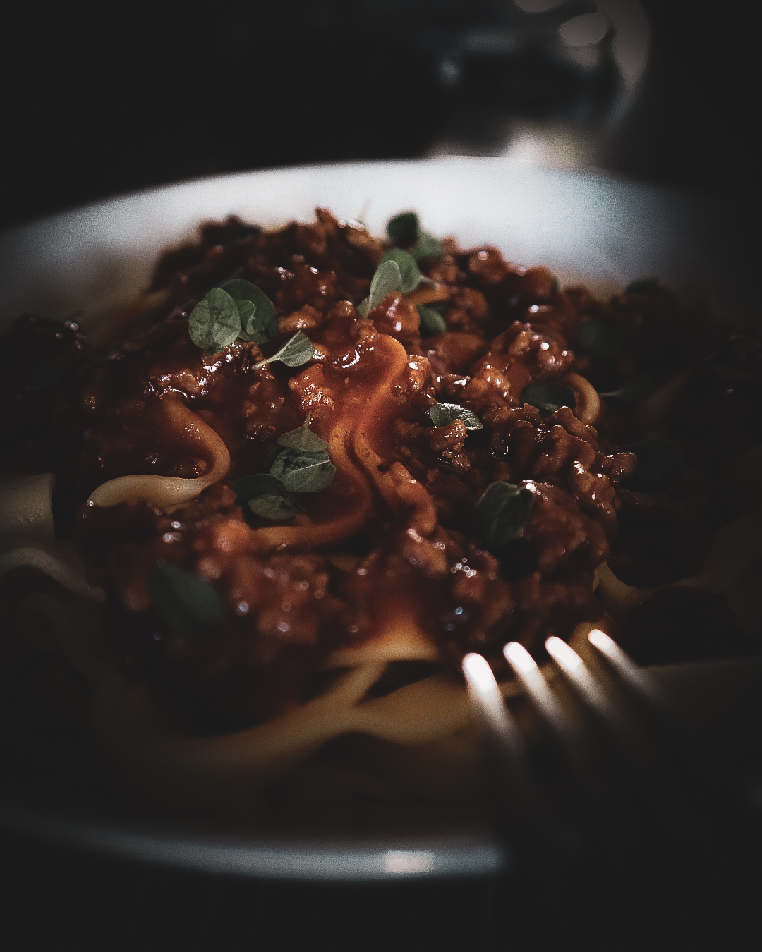 Assiette de pâtes avec sauce bolognaise et herbes fraîches, illustration des féculents dans une alimentation équilibrée